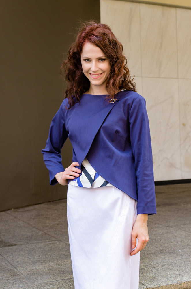 Our model, Jessie, is smiling because she feels great in our Overlapping Front Jacket in Navy Blue, Cap Sleeve Corset Top and Pencil Skirt with Scallop.