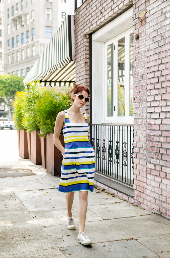 Our model, Jessie, is wearing our 50-s inspired  Square Neckline dress in Blue and Yellow Stripe. Princess lines are extending into box pleats. Open back, shoulder straps and pockets are simply chic!