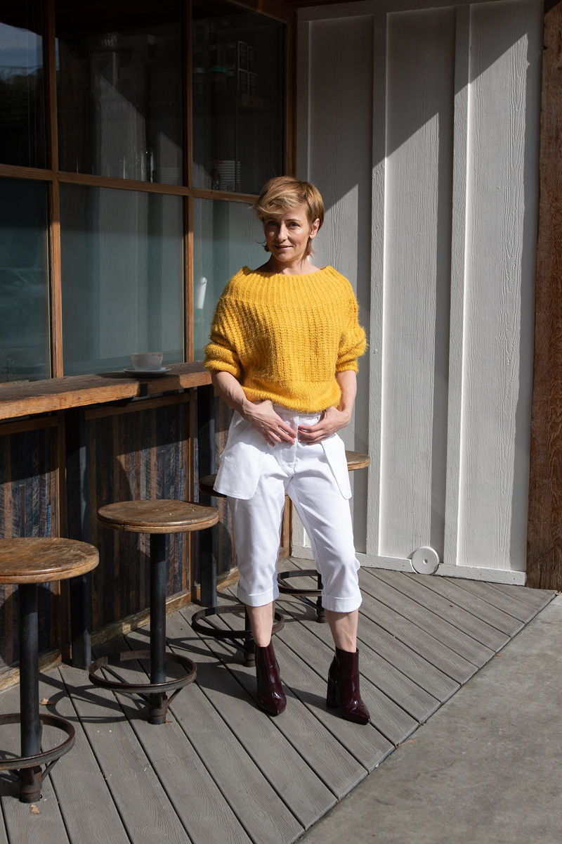 Our creative director, Inga Goodman, is wearing  a pair of Loose Pocket Cropped Pants in White from our latest Spring Summer collection combined with off shoulder yellow sweater and ankle boots in eggplant from her personal collection.